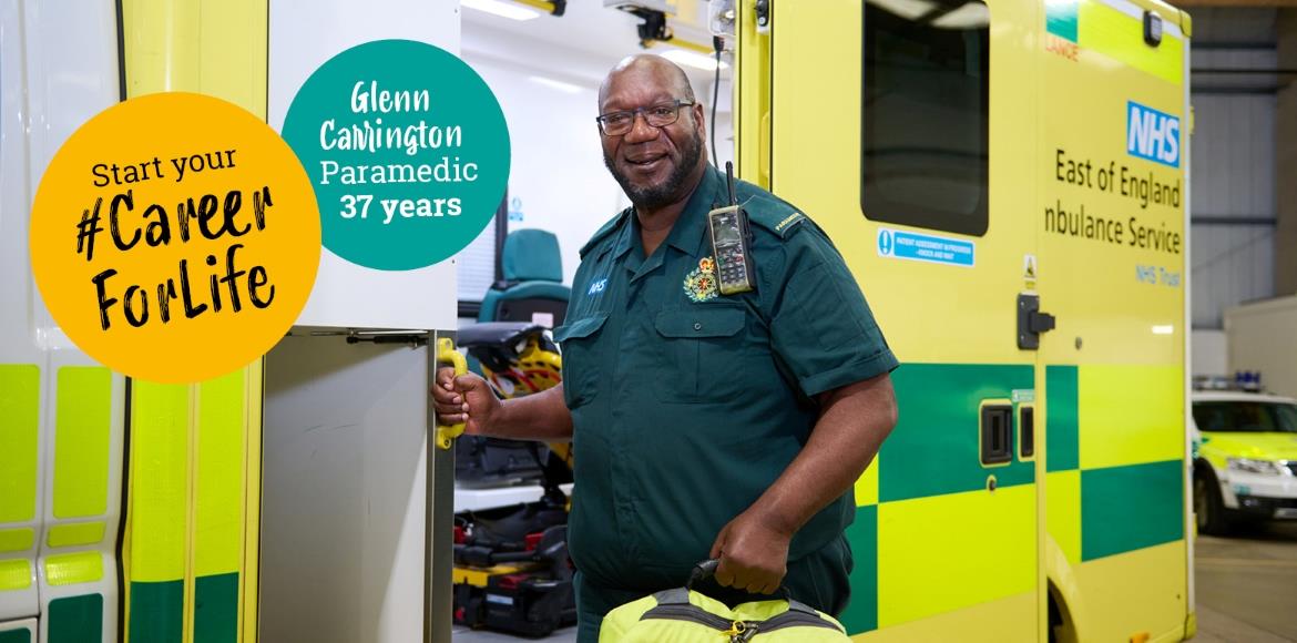 Male paramedic in green uniform getting equipment out of the ambulance with text bubble that reads 'Start your #CareerForLife. Glenn Carrington, Paramedic, 37 years'